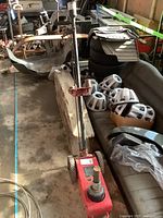 Full view of red Mac Tools pneumatic jack on wheels in workshop setting