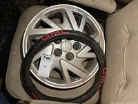 Set of 4 Pontiac 14 inch wheel covers stacked and one GMC steering wheel cover on top, showing condition and design.