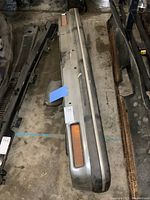 Top view of the full metal front bumper with integrated amber side signal lights, showing surface wear and dirt.