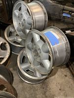 Four GM S10 Blazer mag wheels stacked showing silver finish and 5 bolt pattern.