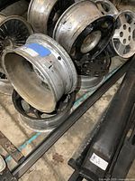 Photo showing multiple used GM wheels stacked, highlighting the size and metal construction.