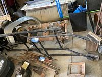 Overview of the metal frame snowmobile lift showing square tubing construction and attached wheels.