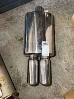 Top view of stainless steel muffler showing dual cylindrical exhaust tips and rectangular muffler body