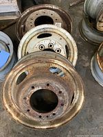 Three steel truck wheels stacked together showing different diameters and rusted surfaces.