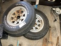 Front view of stacked trailer tires on rusty steel rims showing TRACKERmarine brand and tire details.