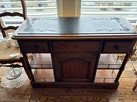Front view of the solid wood sideboard buffet showing two drawers, central cabinet, carved details, and brass railings on lower shelf.