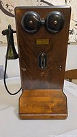 Front view of the vintage Northern Electric wall-mounted telephone showing wood finish, dual bells, mouthpiece on wire.