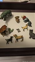 Full view of collection showing 10 cast iron animal figurines in various colors and poses.