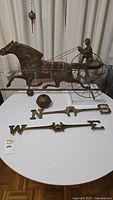 Overall view of weathervane assembly on table with mounting balls and letter arms
