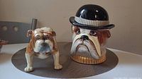 Porcelain Bulldog figurine and bulldog cookie jar side by side on surface