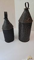 Two black punched tin lanterns, Paul Revere-style, showing different angles including front and side views.