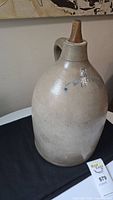 Full view of the 2-gallon stoneware jug with handle and cork stopper, showing overall shape and color.