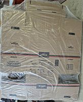 Photo showing flat-packed corrugated cardboard filing boxes with Offix branding, shrink wrapped together.