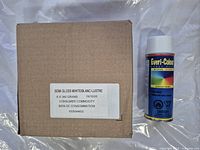 Six cans of Everi-Colour semi-gloss white spray paint and the brown cardboard box they come in with quantity and weight label.