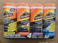 Photo of four Armor All cleaning wipe packs including original protectant wipes, two original cleaning wipes, and one glass wipes pack.