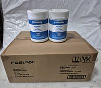 Front view of two Fusion antiseptic wipes containers placed on top of the cardboard case showing product name and wipe quantity.
