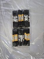 Six packs of black hook and loop fastener strips arranged in two rows of three, wrapped in plastic.