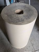 Front view of the large roll of masking paper showing its size and top surface with printed text.