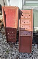 Front view of the two metal car ramps showing traction holes and slight rust.