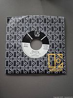 Front of first 7-inch vinyl record with label showing The Doors, Elektra logo, 50th Anniversary MONO issue text, and track information, in patterned sleeve.