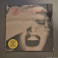 Front of sealed vinyl album showing blurred screaming face and Third Eye Blind logo