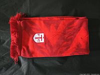 Folded red Toronto FC scarf with fringe at end and embroidered logo visible.