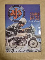 Front view of the vintage AJS Motorcycles steel sign showing the colorful poster ad design with rider and bike.