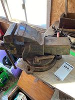 Front side view showing the full heavy bench vice with worn yellow paint remnants.