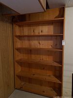 Front view of the large pine wood bookcase with five shelves.