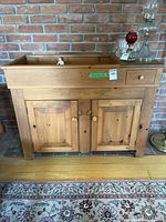 Front view of pine dry sink showing single drawer and double cabinet doors.