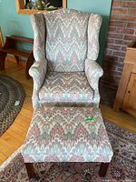 Full view of the wing back chair and ottoman showing overall style and fabric pattern.