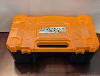 Orange and black Beyblade Burst carrying case closed with logo on top and handle visible