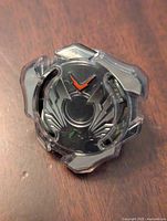 Top view showing clear plastic with wing designs and red V symbol on black base.