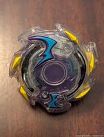Top view of Beyblade Burst Wyvron toy spinning top showing purple, yellow and blue attack ring design.