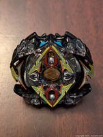 Top view of Beyblade Burst Zillion Zeutron spinning top showing decorative layered plastic design with lightning bolts and central gold emblem.