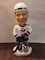 Front view of Jarome Iginla Team Canada bobblehead in white hockey uniform with gold medal on base and 'IGINLA' nameplate.