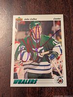 Front of the hockey card showing John Cullen in green Hartford Whalers jersey with a purple autograph across the front.