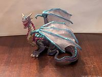 Side view of the blue dragon figure with visible wings, head, and claws.