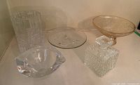 Photo showing all six glassware items arranged on a white surface, including pedestal bowl, Finland vase, decanter, thick crystal bowl, etc.