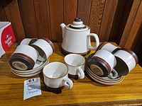 Full view of the complete set including coffee pot with lid, cups, saucers, and a bowl