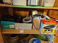 Shelf with multiple vintage electronics including a piano calculator, Phillips radio alarm clock, and USB hub box