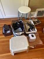 Overview of shower stool, fan, hairdryer, plastic step stool, tissue box cover, and baskets containing various items