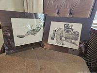 Photo showing both framed Indigenous art prints by Ferg side-by-side on a chair: 'Feast Dish' and 'Haida Bear'
