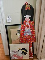 Set of three Japanese art pieces including two framed woodblock prints and one large paper art figure with vibrant kimono design