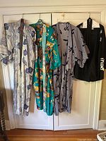 Full view of four hanging Japanese kimonos showing different colors and patterns