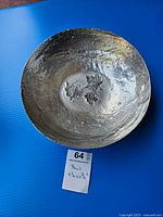 Top view showing the round pewter bowl with three embossed maple leaves at the interior base.