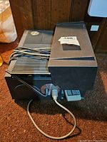 Side view of Sawyer's 35mm slide projector showing side panel and ventilation ridges, power cord wrapped on top, and attached slide tray.