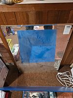 Front view of the vintage wall mirror showing reflective surface and metal clips on top edge.