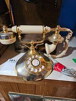 Leever Brothers brass and ivory-coloured rotary desk phone with handset and cord.