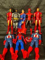 Group shot of ten 12-inch superhero figures and shield